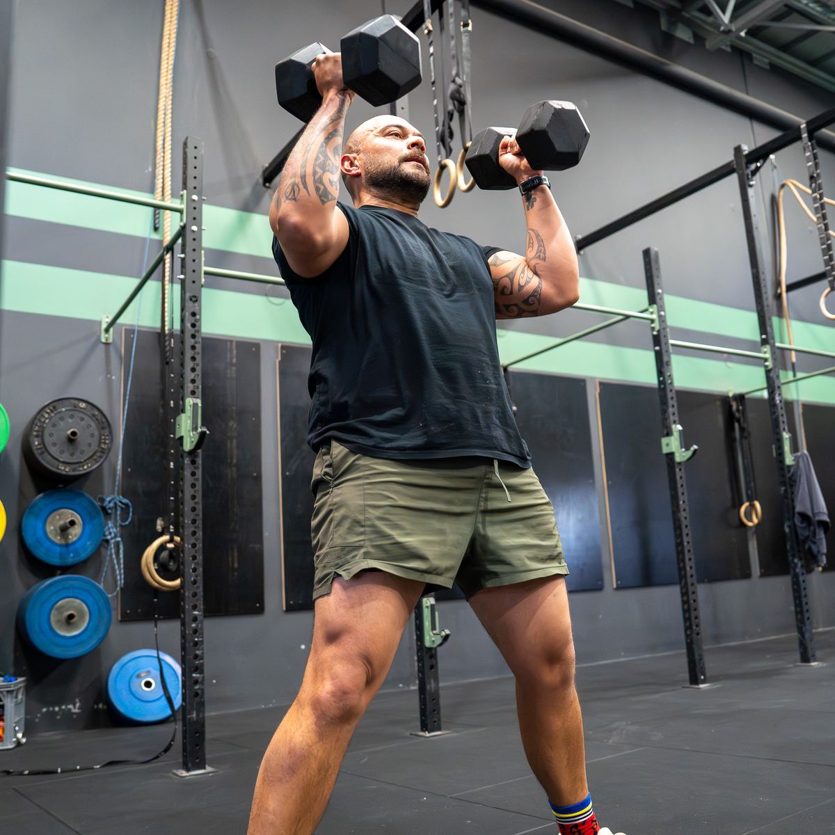 A member pressing two dumbbells overhead