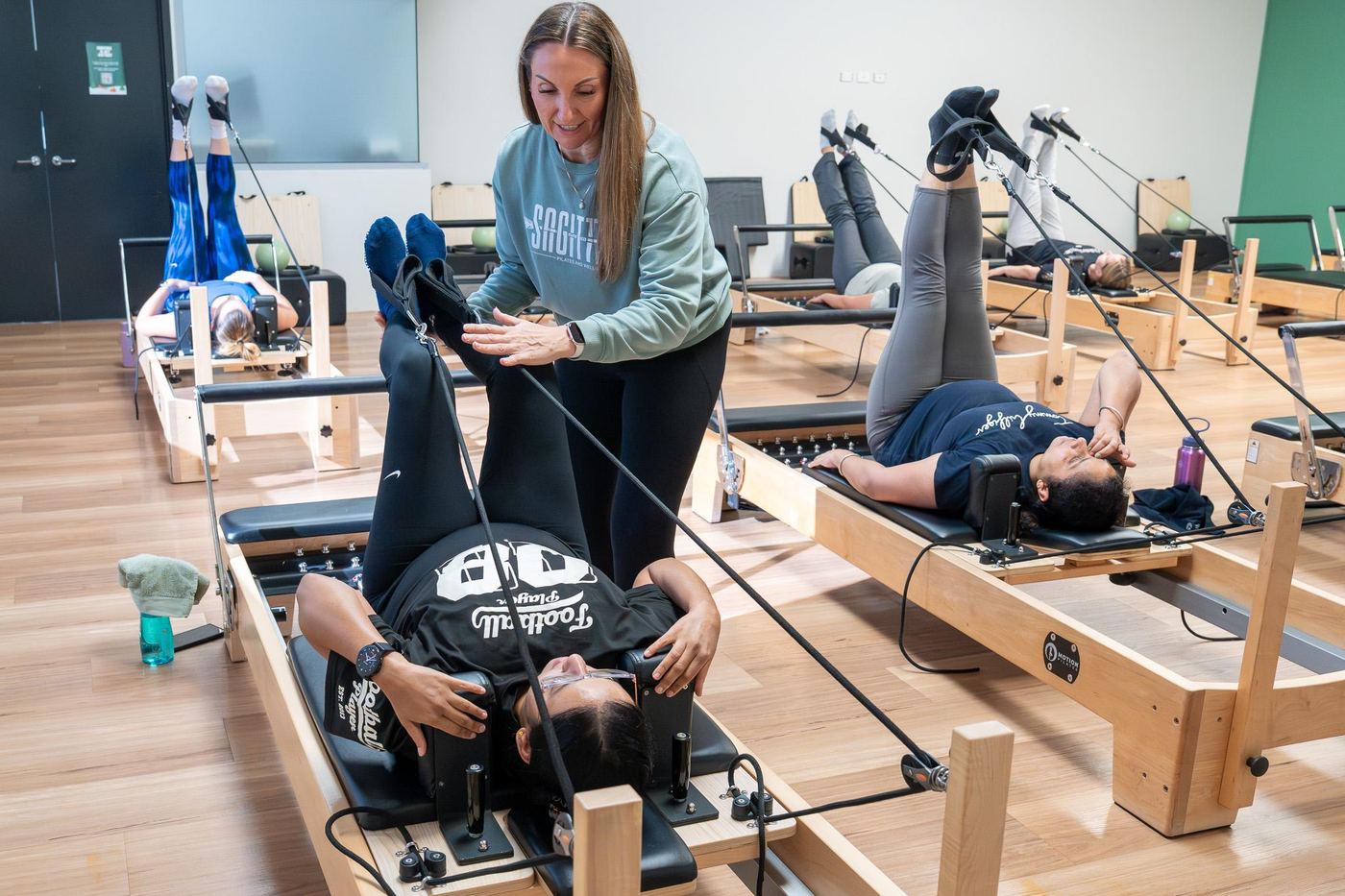 An instructor adjusting a member on the reformer